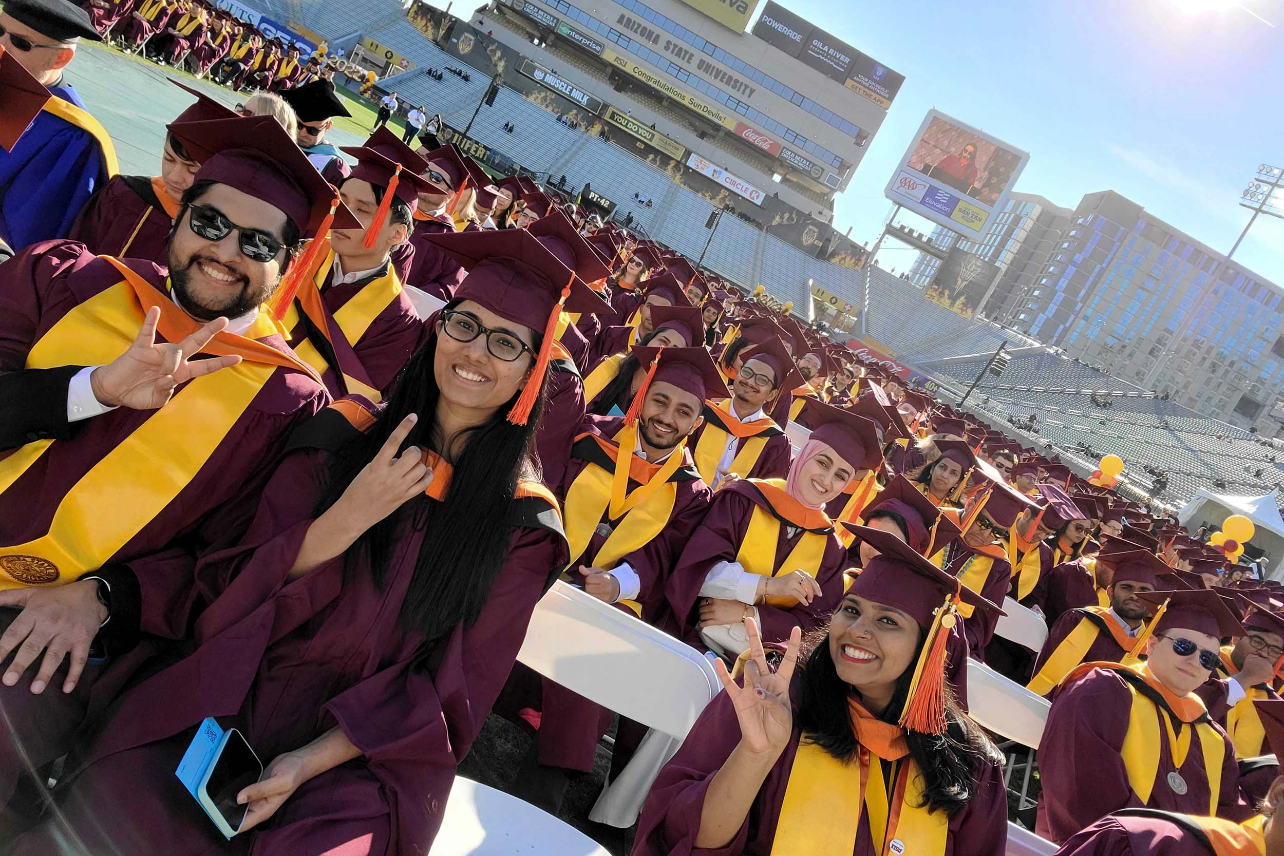 The Class of 2022 ASU Engineering graduates sit in their seats on the field inside Sun Devil Stadium